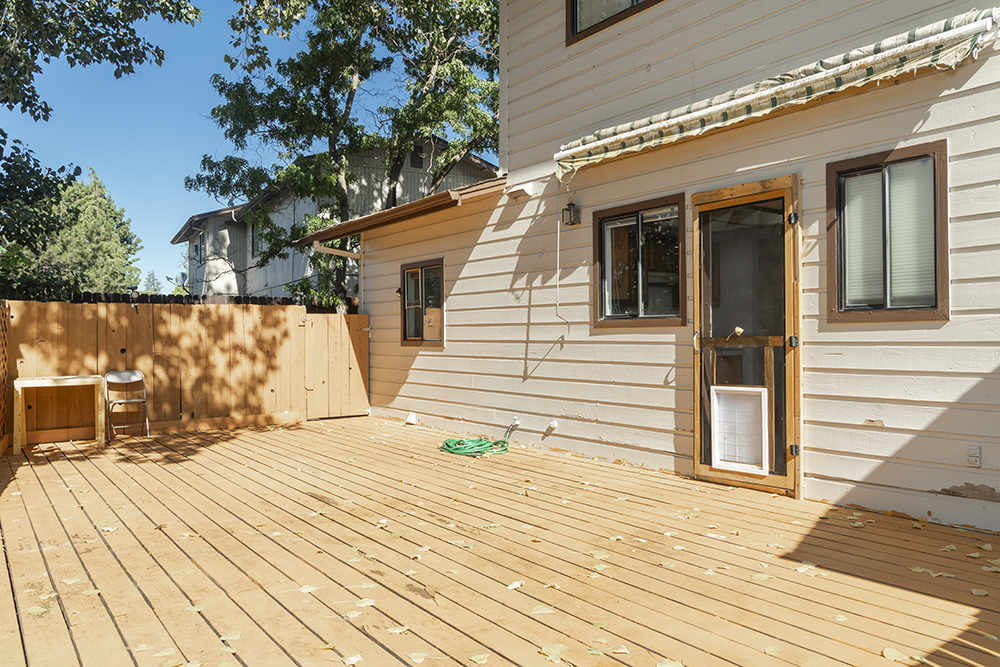 Private fenced backyard with spacious wooden deck and side yard access.