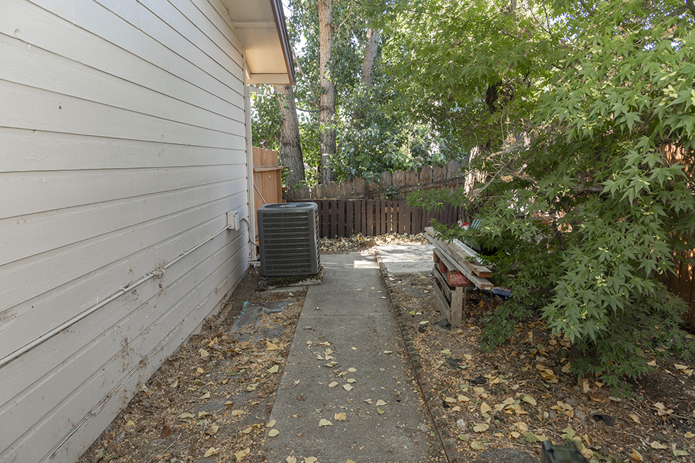 Side yard with gravel path and fencing, suitable for pets or additional garden space.