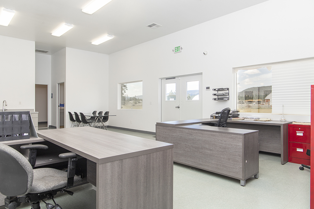 Private office or reception space inside the building with large window, tiled flooring, and access to utilities.