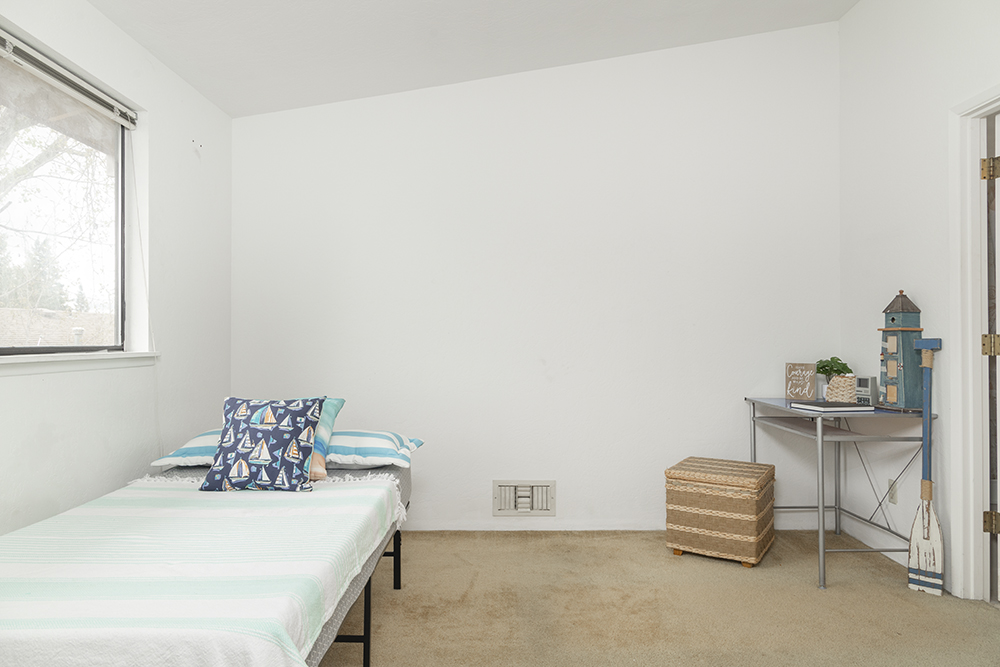 Secondary upstairs bedroom with bright window and closet space.