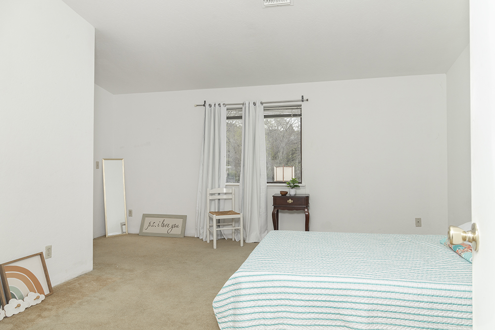 Upstairs primary bedroom with large closet, neutral carpet, and natural light.