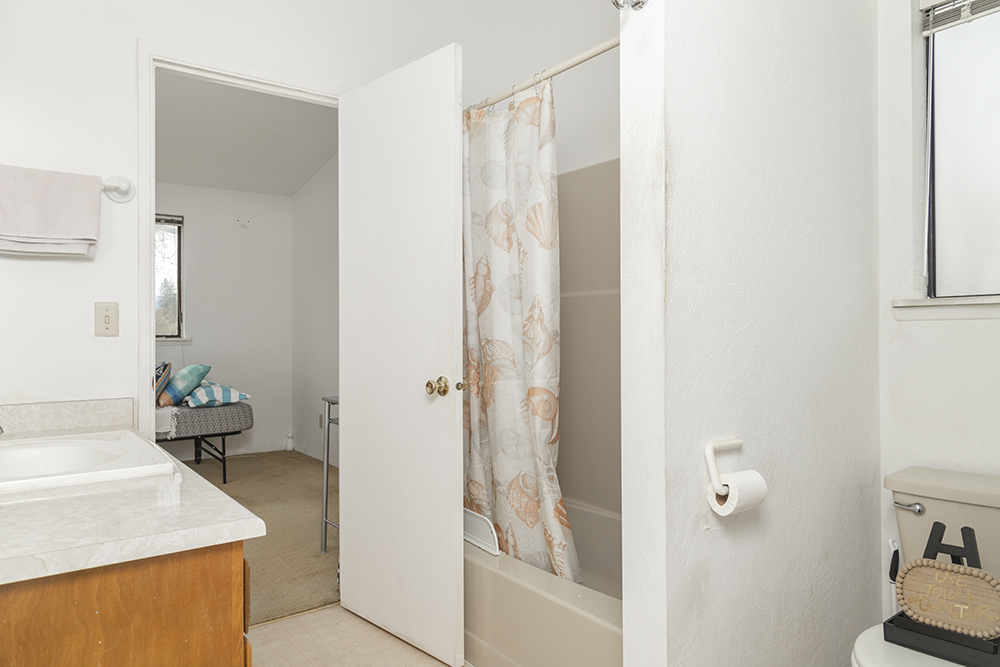 Secondary upstairs bedroom with bright window and closet space.